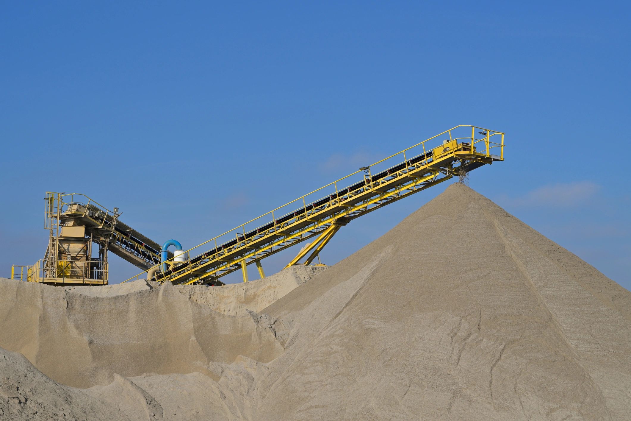 Industrial conveyor system handling raw mineral material